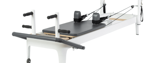 Reformer Pilates z wyściełanymi, konturowanymi regulowanymi uchwytami.