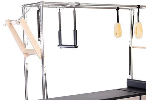 Sprzęt Pilates z drewnianą belką do pchania i akcesoriami.