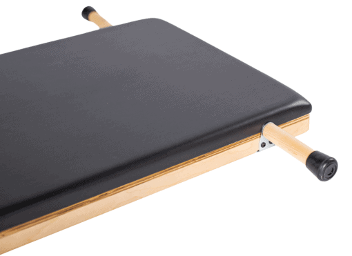 Podniesiony produkt Pilates z trwałą czarną tapicerką i ergonomicznymi uchwytami.