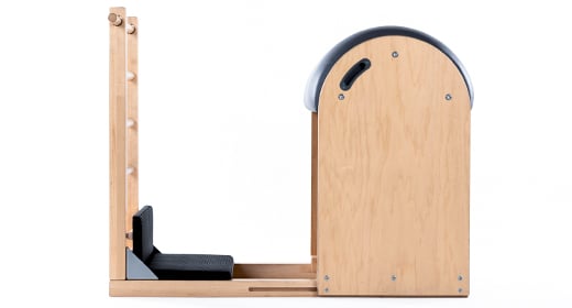 Durable maple wood Pilates barrel with foam padding and ladder.