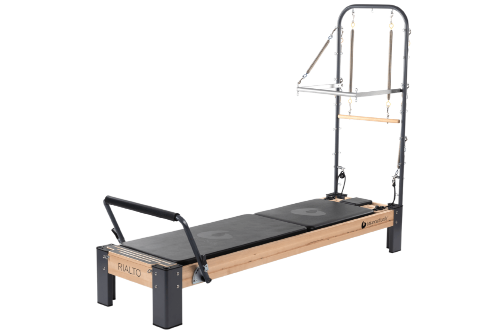 Rialto Reformer z Wieżą do Pilates, charakteryzujący się wielofunkcyjnym designem.