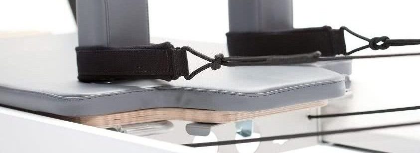 Profesjonalny wózek Pilates z wbudowanym zagłówkiem i tapicerką w kolorze burzowym.