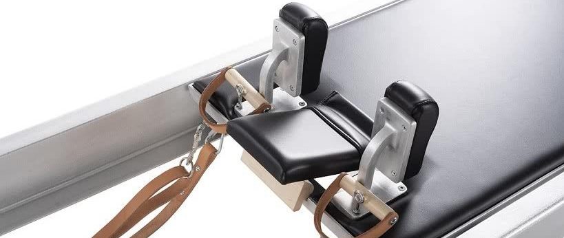 Wózek reformera Pilates z płynnym ruchem i czarnym wykończeniem.