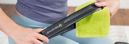 Pilates equipment maintenance: wiping Balanced Body handle.