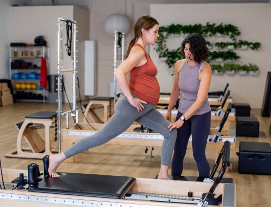 Pilates studio equipment in use during a prenatal session.