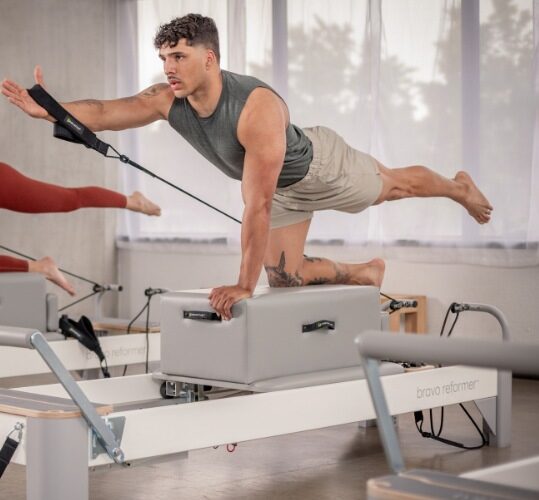 Man performing Pilates on a Bravo Reformer at a studio.