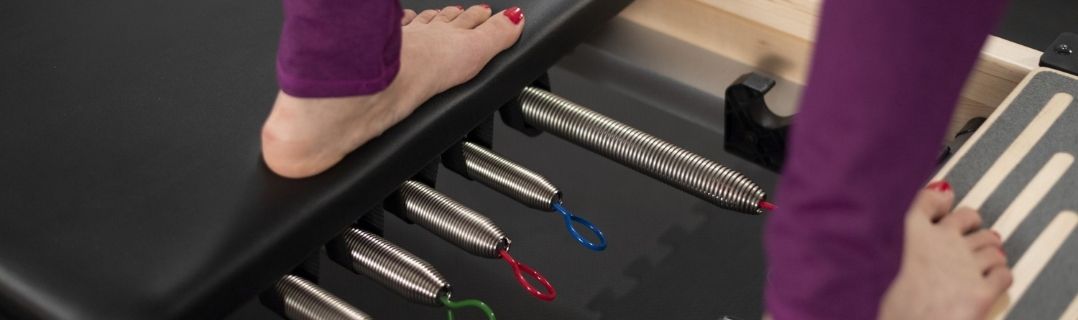 Osoba na sprzęcie Pilates Reformer.
